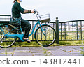 Woman riding a power-assisted bicycle 143812441