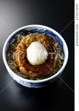 一張黑色背景上的照燒漢堡飯照片,上面放著一個蛋餅。 一張黑色背景上的照燒漢堡飯照片,上面放著一個蛋餅。 143813605