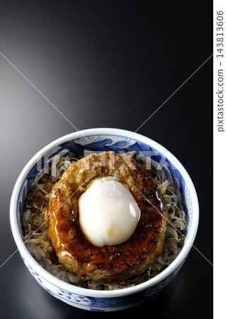 一張黑色背景上的照燒漢堡飯照片，上面放著一個蛋餅。 143813606