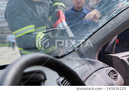 Firefighters Performing Vehicle Rescue Using Hydraulic Tool to Remove Cracked Windshield After Accident Firefighters Performing Vehicle Rescue Using Hydraulic Tool to Remove Cracked Windshield After Accident 143816120