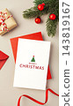 Merry christmas greeting card on red envelop with gift box, red ribbon and xmas ornament on beige background 143819167