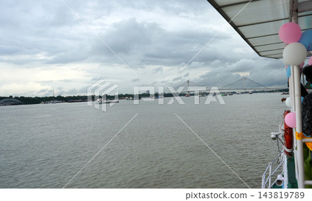 View of Vidyasagar Setu bridge and river vessels on Hooghly river from a decorated cruise boat in Kolkata 143819789
