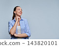 Thoughtful young woman touching chin and looking away at copy space on grey background 143820101