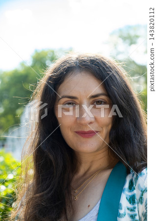 Close up headshot of beautiful middle aged brunette woman looking at camera Close up headshot of beautiful middle aged brunette woman looking at camera 143820112