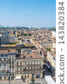 Aerial view of the historic city center of Bordeaux in France, featuring traditional stone buildings and rooftops under a clear blue summer sky 143820384