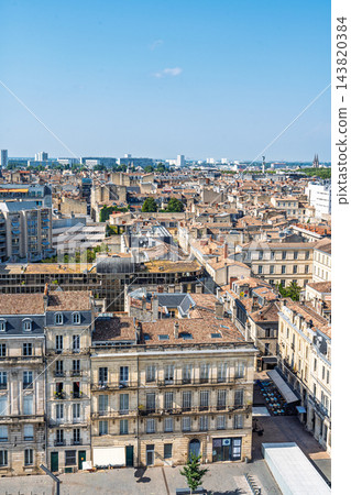 Aerial view of the historic city center of Bordeaux in France, featuring traditional stone buildings and rooftops under a clear blue summer sky Aerial view of the historic city center of Bordeaux in France, featuring traditional stone buildings and rooftops under a clear blue summer sky 143820384