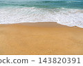 Gentle ocean waves washing over golden sand on a sunny beach in France, creating a peaceful coastal scene for summer travel and relaxation themes 143820391
