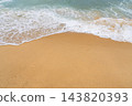 Gentle ocean waves washing over golden sand on a sunny beach in France, capturing the serene beauty of the Atlantic coastline during summer travel 143820393