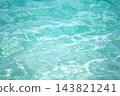Sparkling turquoise ocean water surface with gentle ripples and bright sun glares reflecting in clear sea during tropical summer day 143821241
