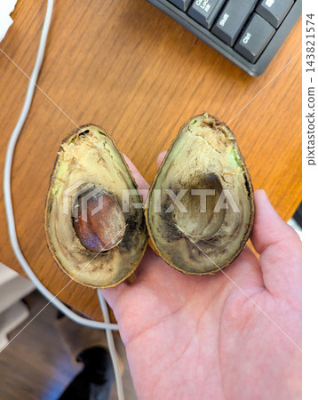 失去新鮮度並變黑的酪梨橫截面。 失去新鮮度並變黑的酪梨橫截面。 143821574