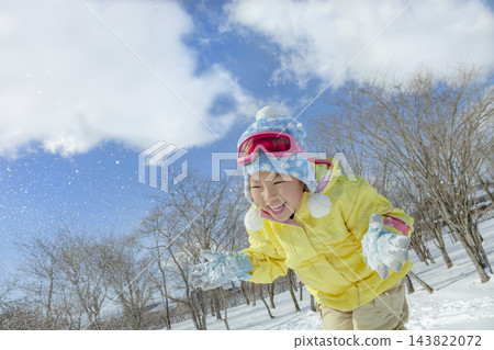一個女孩在公園的雪地裡玩耍 一個女孩在公園的雪地裡玩耍 143822072