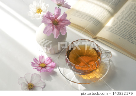 在秋日的陽光下,品茶讀書;粉紅色的波斯菊和一本打開的書,構成了美好的生活。 在秋日的陽光下,品茶讀書;粉紅色的波斯菊和一本打開的書,構成了美好的生活。 143822179