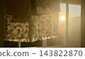 Warm sunlight shining through a window with hanging laundry and translucent fabric, creating a nostalgic cozy home atmosphere 143822870