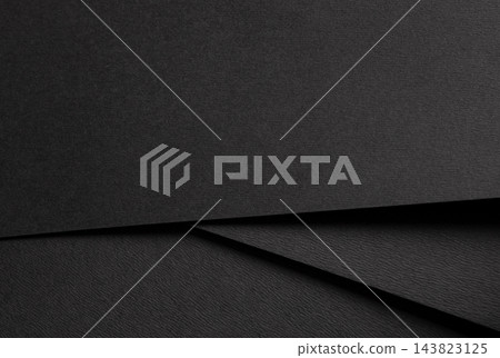 Black paper texture, layered sheets with diagonal lines and folded edges. Dark background close up, matte surface with fold and shadow. Minimalistic abstract material. 143823125