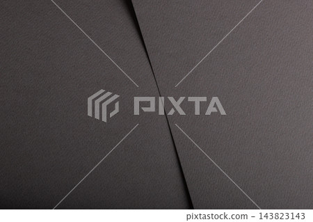 Black paper texture, dark grey sheet with diagonal fold and crease. Charcoal matte surface close up, fine grain with edge and subtle shadow. Monochrome designer paper, sleek minimalistic 143823143