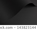 Black paper texture, curled sheet with curve and fold. Dark charcoal matte surface close up, bent material with grain and shadow. Monochrome designer paper, sleek minimalistic backdrop. 143823144