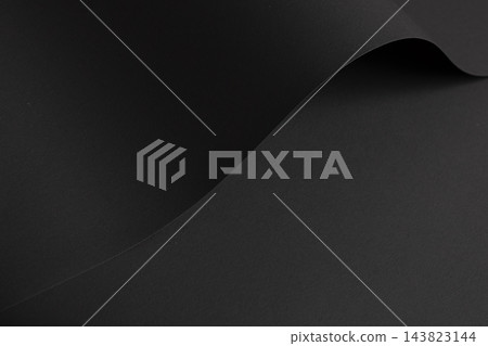 Black paper texture, curled sheet with curve and fold. Dark charcoal matte surface close up, bent material with grain and shadow. Monochrome designer paper, sleek minimalistic backdrop. Black paper texture, curled sheet with curve and fold. Dark charcoal matte surface close up, bent material with grain and shadow. Monochrome designer paper, sleek minimalistic backdrop. 143823144