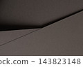 Gray paper texture, folded sheet with diagonal fold and crease. Charcoal matte surface close up, overlapping sheets with bent edge and shadow. Monochrome backdrop, geometric shape with grain 143823148