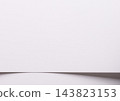 White paper texture, bent sheet with curved fold and edge. Pastel pale pink surface close up, wave shape with curl and shadow. Matte designer paper, smooth minimalist backdrop. 143823153