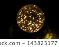 Golden LED lights glow fantastically inside glass spheres floating in the darkness. Golden LED lights glow fantastically inside glass spheres floating in the darkness. 143823177