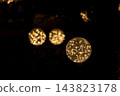 A fantastical scene where three spherical illuminations create a beautiful golden bokeh effect against a black background. A fantastical scene where three spherical illuminations create a beautiful golden bokeh effect against a black background. 143823178
