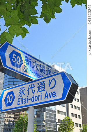 在永泰通和新大橋通的交叉路口,豎立著一塊藍色的路牌,周圍環繞著藍天和綠樹。 在永泰通和新大橋通的交叉路口,豎立著一塊藍色的路牌,周圍環繞著藍天和綠樹。 143823243