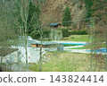 Serene afternoon at an outdoor pool surrounded by nature in a tranquil setting, with trees and hills creating a peaceful atmosphere 143824414