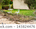 Picture a delightful garden filled with vibrant greenery, featuring elegant vintage white furniture that invites relaxation on a tranquil afternoon 143824476