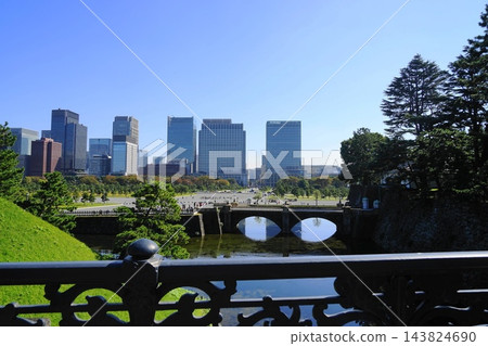 從皇宮正門鐵路橋上望去，二重橋和丸之內建築群在藍天的襯托下熠熠生輝。十月，皇宮，丸之內建築群及正門鐵路橋 143824690