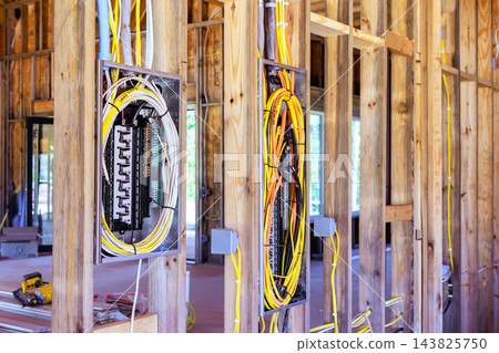 Electricians have routed cables through open timber framing at home construction site Electricians have routed cables through open timber framing at home construction site 143825750