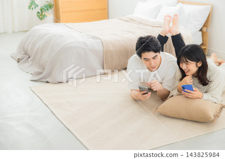 夫婦在床上看智慧型手機 夫婦在床上看智慧型手機 143825984