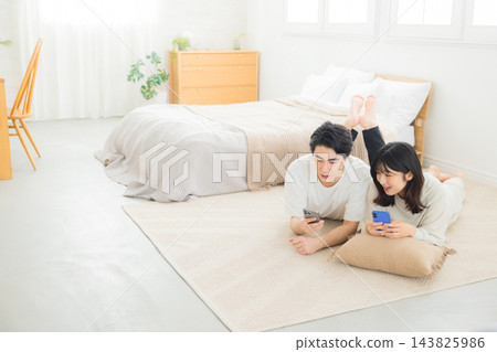 夫婦在床上看智慧型手機 夫婦在床上看智慧型手機 143825986