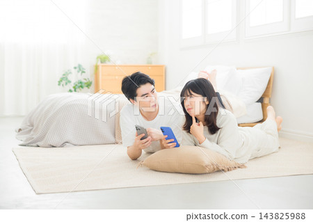 夫婦在床上看智慧型手機 夫婦在床上看智慧型手機 143825988