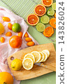 Citrus fruits are being prepared for Christmas drying. Different types of citrus are placed on a cutting board and drying rack in a home kitchen. The scene shows a festive activity 143826024