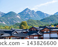 Traditional Korean Hanok Houses and Tiled Roofs against Bukhansan Mountain in Eunpyeong Hanok Village, Seoul 143826600