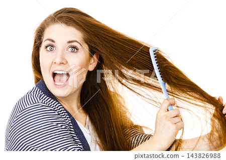 Woman brushing her long hair using comb Woman brushing her long hair using comb 143826988