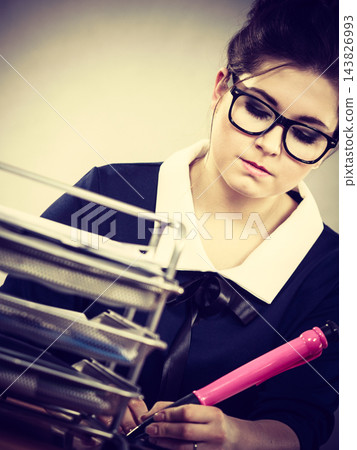 Business woman in office writing something down Business woman in office writing something down 143826993