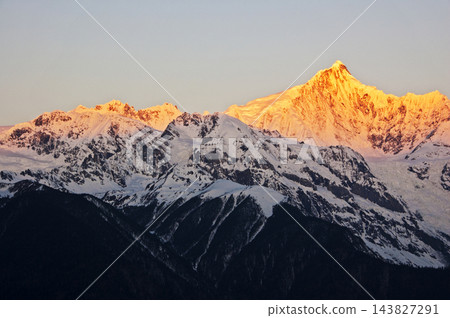 梅里雪山的皚皚雪峰沐浴在金色的陽光下。 梅里雪山的皚皚雪峰沐浴在金色的陽光下。 143827291