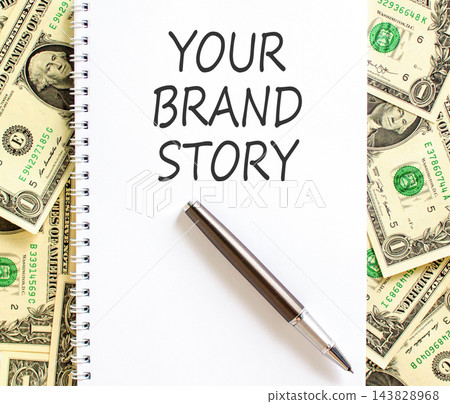 Branding and your brand story symbol. Concept words Your brand story on beautiful white note. Beautiful dollar bills background. Business branding your brand story concept. Copy space. Branding and your brand story symbol. Concept words Your brand story on beautiful white note. Beautiful dollar bills background. Business branding your brand story concept. Copy space. 143828968