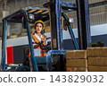 Woman worker at forklift driver happy working in industry factory logistic ship. 143829032