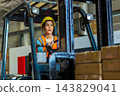 Woman worker at forklift driver happy working in industry factory logistic ship. 143829041