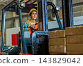 Woman worker at forklift driver happy working in industry factory logistic ship. 143829042