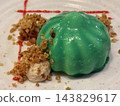 Green Glazed Dessert with Crumble on White Plate 143829617