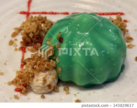 Green Glazed Dessert with Crumble on White Plate 143829617