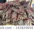 Bundles of dried sage tied with red string displayed in a market stall for traditional cleansing use 143829694