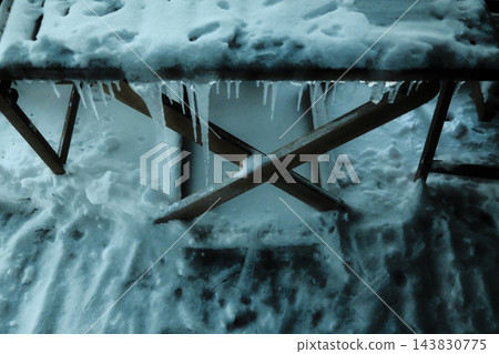 Snow-covered table with hanging icicles 143830775