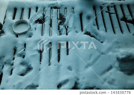 Snow-covered wooden table with ashtray in winter 143830776