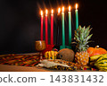 Kwanzaa kinara with seven candles and harvest fruits 143831432