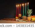 Kwanzaa kinara with seven candles and harvest offerings 143831435