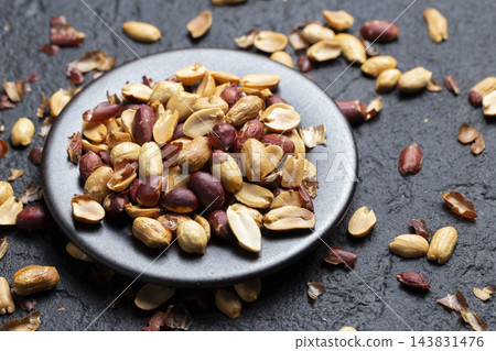 Pile of roasted peanuts on black background, space for text Pile of roasted peanuts on black background, space for text 143831476